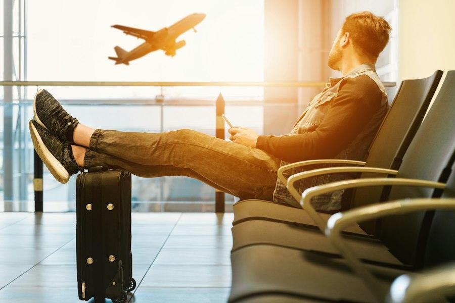 Traveller relaxing in an airport lounge as a plane takes off